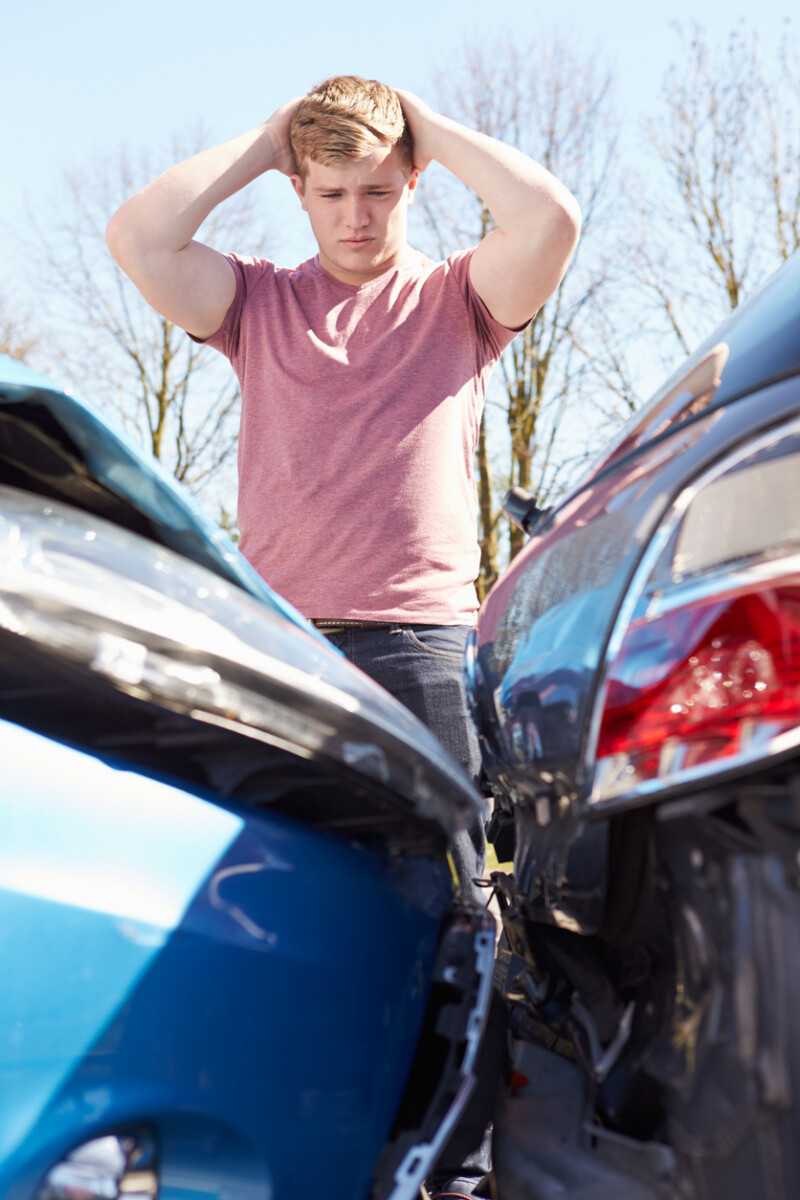 driver inspecting damage after traffic accident